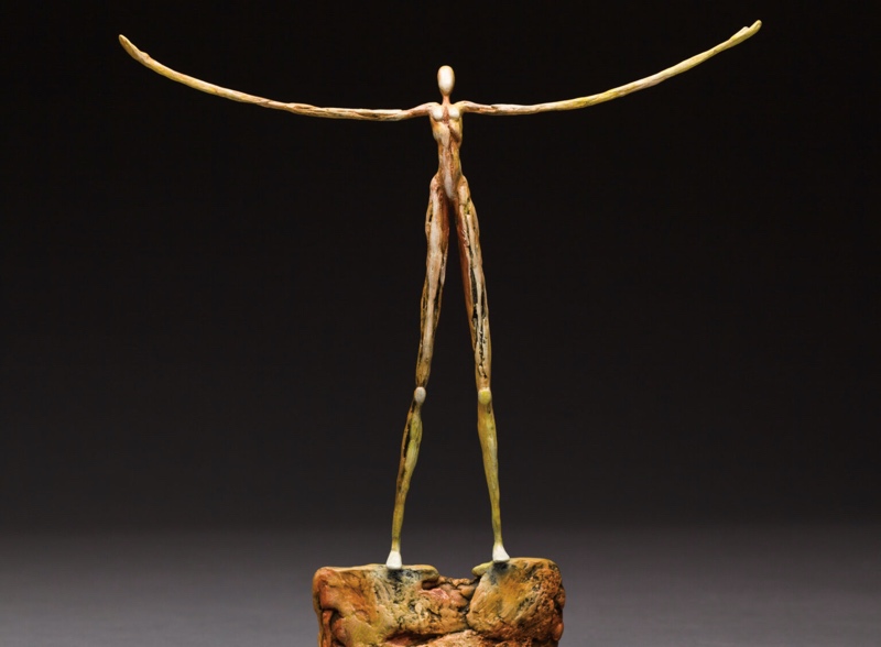 figure with arms out in bronze