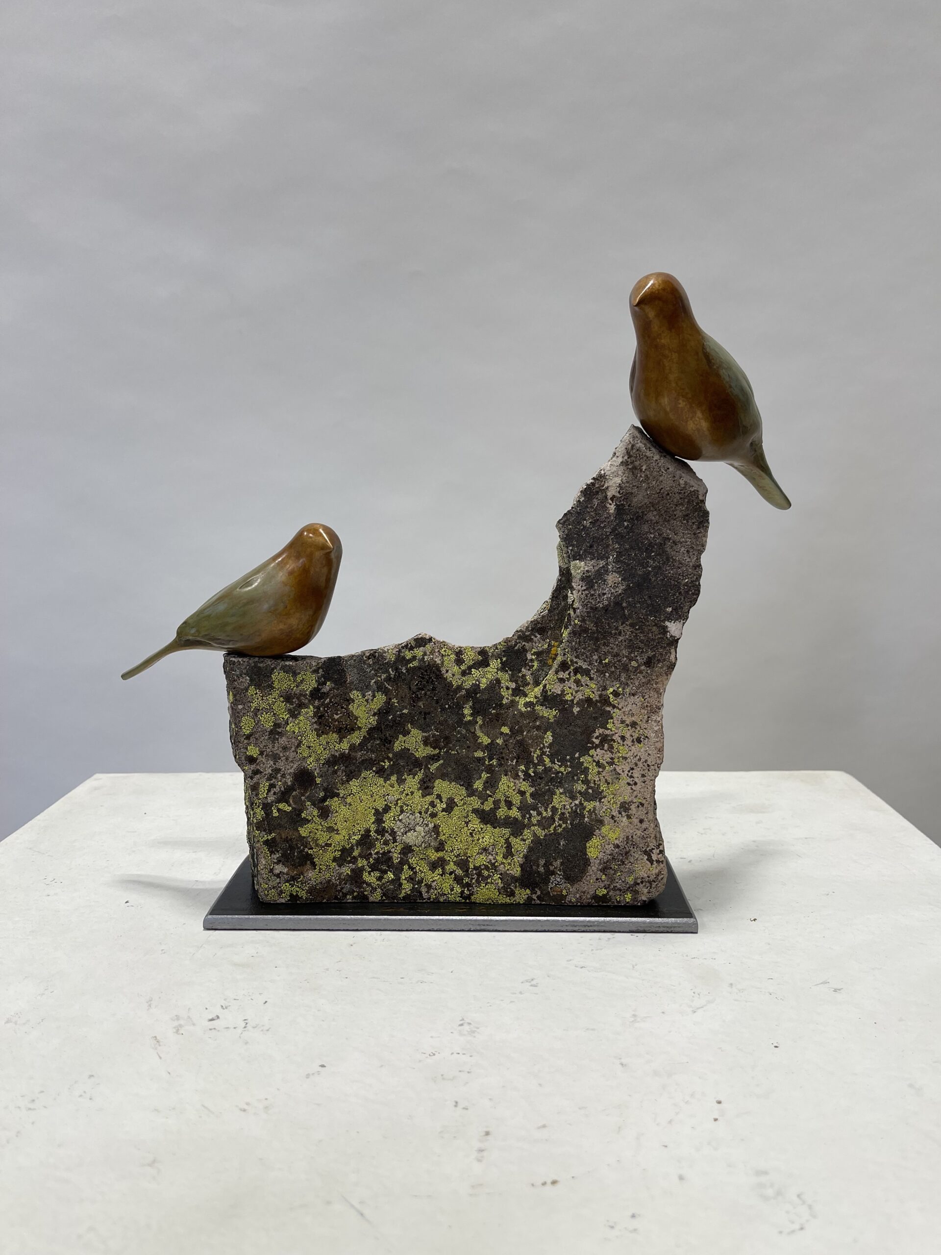 two bronze birds on stone