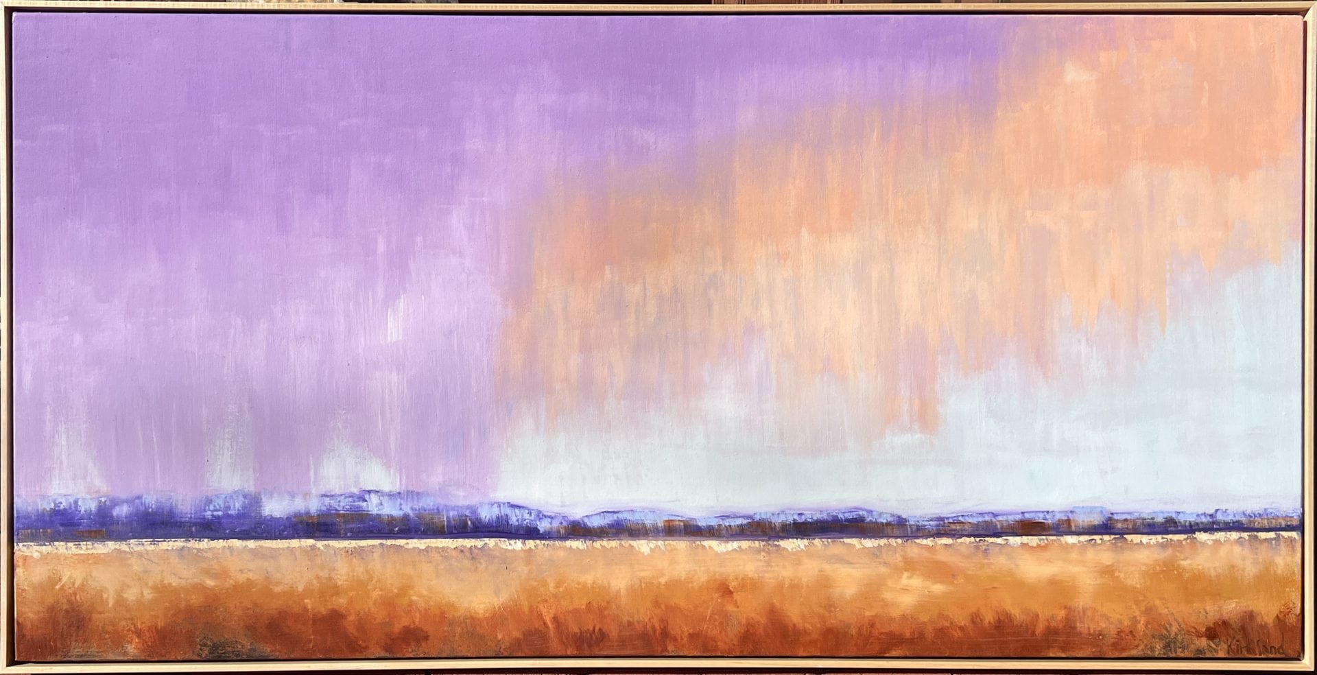 lavendar and peach clouds over warm landscape
